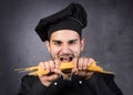 Portrait of a chef cooker in black uniform with spaghetti. Royalty Free Stock Photo