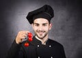 Portrait of a chef cooker in black uniform with tomatos. Royalty Free Stock Photo