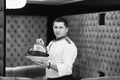 Portrait chef presenting a dish at the hotel restaurant, steaming a dish with a cover lid black and white tones