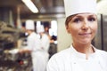 Portrait, chef and woman in kitchen for cooking, catering and presentation of food in restaurant. Professional, culinary