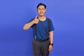 Portrait of cherful Asian man showing thumbs up or sign of approval isolated on purple background Royalty Free Stock Photo