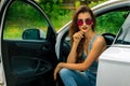 Chic young brunette in sunglasses in the car