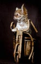 Portrait of a little chihuahua puppy standing on its hind legs in a wooden toy bicycle on a brown dark background Royalty Free Stock Photo