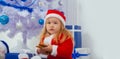 Portrait of child baby boy in Christmas Santa hat hold gingerbread cookies on home decorated background. Merry christmas Royalty Free Stock Photo