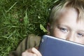 Portrait of Child blond young boy playing with a digital tablet Royalty Free Stock Photo