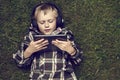 Portrait of Child blond young boy playing with a digital tablet computer outdoors lying on grass Royalty Free Stock Photo