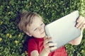 Portrait of Child blond young boy playing with a digital tablet Royalty Free Stock Photo