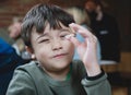 Portrait child boy playing chopstick holding while waiting for lunch. Kid sitting in Japanese restaurant