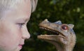 Portrait of child boy playing with toy dinosaur Royalty Free Stock Photo