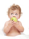 Portrait of a child curly hair eats a green ÃÂ°pple Royalty Free Stock Photo