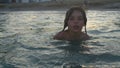 Portrait of a child floating in the sea near the shore in the evening at sunset.