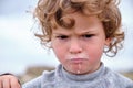 Portrait of a child with a frown and a milk-stained mouth