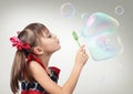 Portrait of Child girl blowing soap bubble forming house, habita Royalty Free Stock Photo