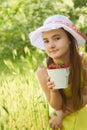 Portrait of child girl with bucket of strawberries