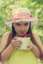 Portrait of child girl with bucket of strawberries