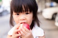 Portrait of child girl eating red apple and looking at camera. Head short of healthy kid eating fresh fruit for snack time. Royalty Free Stock Photo