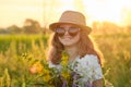 Portrait of child girl in hat sunglasses with flowers in meadow Royalty Free Stock Photo