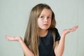 Portrait of child girl shrugging her shoulders making innocent I don`t know expression Royalty Free Stock Photo