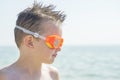Portrait of a child in glasses for swimming against the sea. Kid in spectacles for swimming at the sea. Portrait of playful boy in Royalty Free Stock Photo