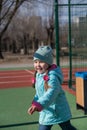 Portrait of a child having fun on a sports field. Five-year-old girl with long pigtails. Childhood. Outside. A sunny spring day Royalty Free Stock Photo