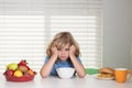 Portrait of child with no appetite. Concept of loss of appetite. Kid preteen boy in the kitchen at the table eating