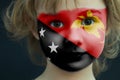 Portrait of a child with a painted flag of Papua New Guinea