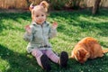 Portrait of child playing with ginger cat in spring backyard garden Royalty Free Stock Photo