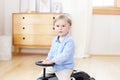 Portrait child riding toy vintage car. Funny kid playing at home. Summer vacation and travel concept. Active little boy driving a Royalty Free Stock Photo