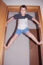 Portrait of a child showing his strength climbing on the door