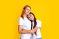 Portrait of child teen girl and mother. Amazing pretty two people mum mom and daughter hugging lovely isolated on yellow