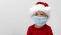 Portrait A child, a toddler in a red santa hat is sick at Christmas. A boy in a medical mask will not go to a matinee in Royalty Free Stock Photo