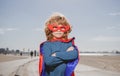 Portrait of child wearing a superhero costume. Super hero child against blue summer sky background. Kid having fun Royalty Free Stock Photo