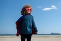 Portrait of child wearing a superhero costume. Super hero child having fun outdoors. Kids power concept. Royalty Free Stock Photo