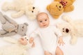 Portrait of a child on a white background with plush bear toys. Baby 6 months among toys. Space for text Royalty Free Stock Photo