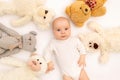 Portrait of a child on a white background with plush bear toys. Baby 6 months among toys. Space for text Royalty Free Stock Photo