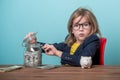 Portrait of child who steals money from parent savings. Adorable young girl wants to be rich. Kid in glasses can count