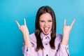 Portrait of childish playful crazy hipster girl rock music lover make horned symbol show tongue out wear good look