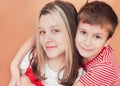 Portrait of children on brown background. Younger brother hugs his older sister with tenderness Royalty Free Stock Photo