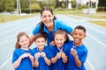 Portrait Of Children With Female Coach Showing Off Winners Medals On Sports Day Royalty Free Stock Photo