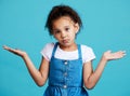 Portrait, children and shrug with a girl on a blue background in studio feeling confused or lost. Kids, question and Royalty Free Stock Photo