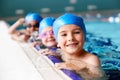 Portrait Of Children In Water At Edge Of Pool Waiting For Swimming Lesson