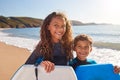 Portrait Of Children Wearing Wetsuits Holding Bodyboards On Summer Beach Vacation Having Fun By Sea Royalty Free Stock Photo