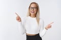 Portrait of chill unbothered attractive businesswoman with blond hair glasses and cropped sweater dancing pointing