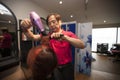 Portrait of chinese hairdresser blow drying customer hair in salon Royalty Free Stock Photo