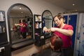 Portrait of chinese hairdresser cutting customer hair in salon