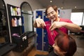 Portrait of chinese hairdresser cutting customer hair in salon