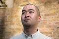 Portrait of chinese young man against red bricks wall background Royalty Free Stock Photo