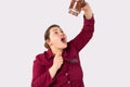Portrait of a chubby woman with a spoon and a large jar of chocolate paste. Excess weight from sweets. Studio white Royalty Free Stock Photo