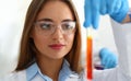 Clever female laboratory worker hold flask with chemical liquid, examine sample in lab
