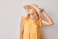 Portrait of clever mature woman in summer yellow clothes touching head thinking chooses